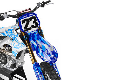 A blue and white camo yamaha dirt bike with number 23, displayed on a black stand against a white studio background front view.