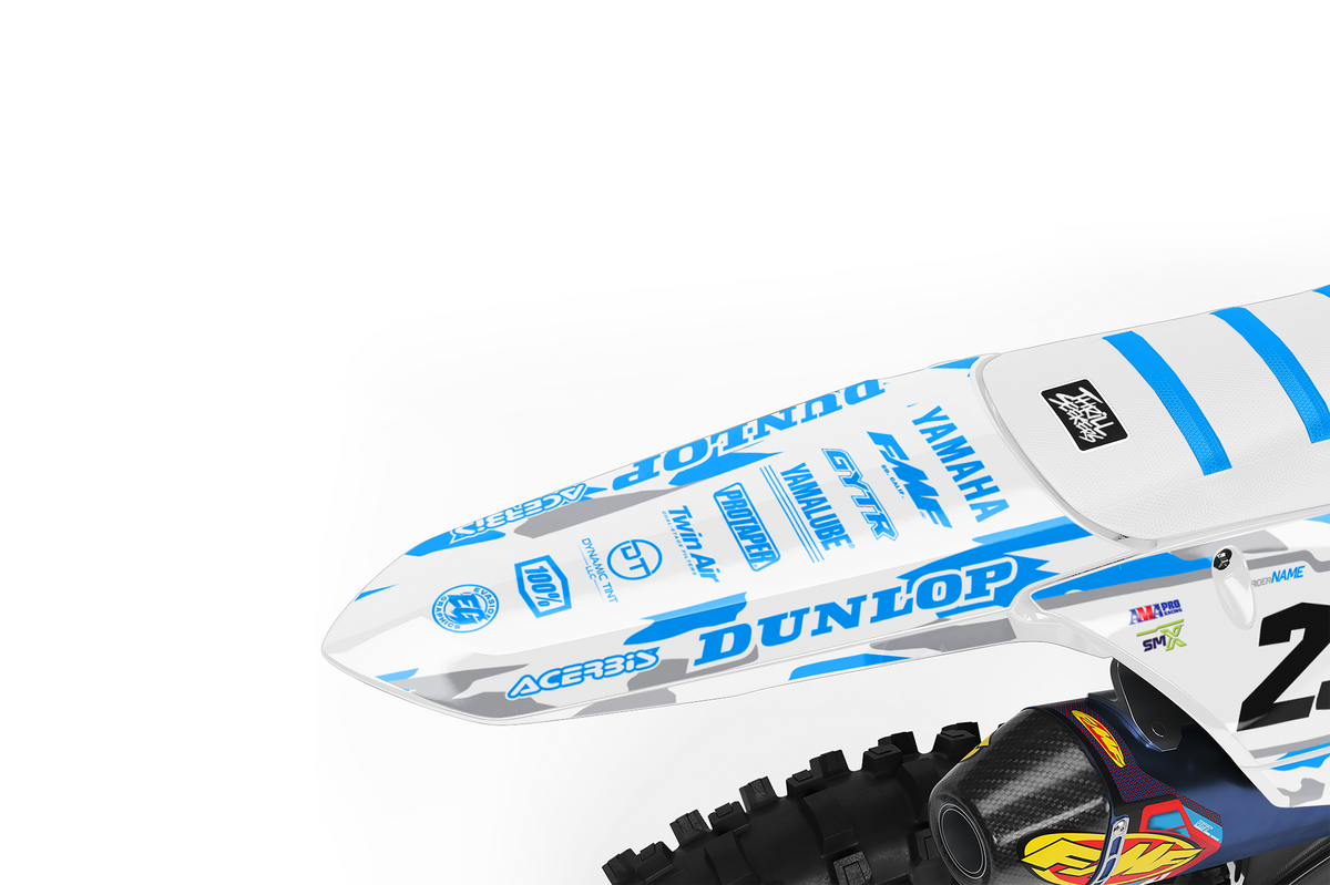 A blue and white camo yamaha dirt bike with number 23, displayed on a black stand against a white studio background rear view.