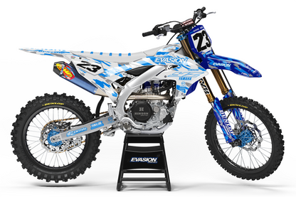 A blue and white camo yamaha dirt bike with number 23, displayed on a black stand against a white studio background.